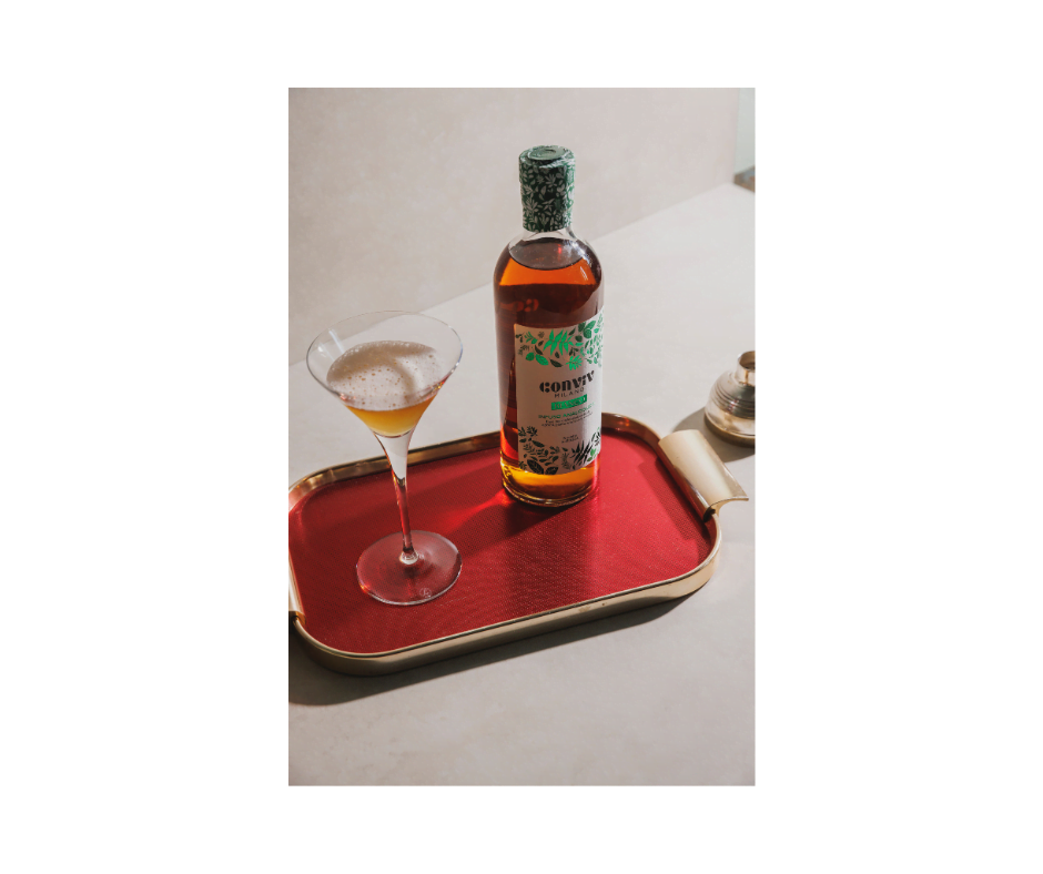 Een vintage dienblad met een fles Conviv Bianco en een martiniglas met schuim