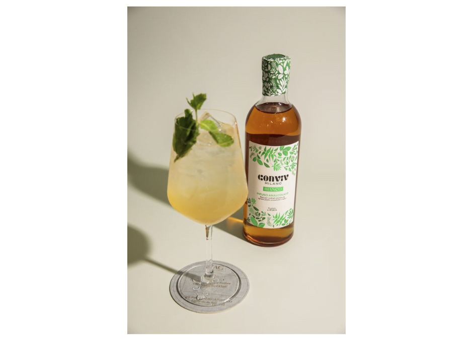 Conviv HG alcoholvrije cocktail. Een fles Conviv Tonic met de cocktail in een groot wijnglas met veel ijsblokjes en een takje munt. Cheers