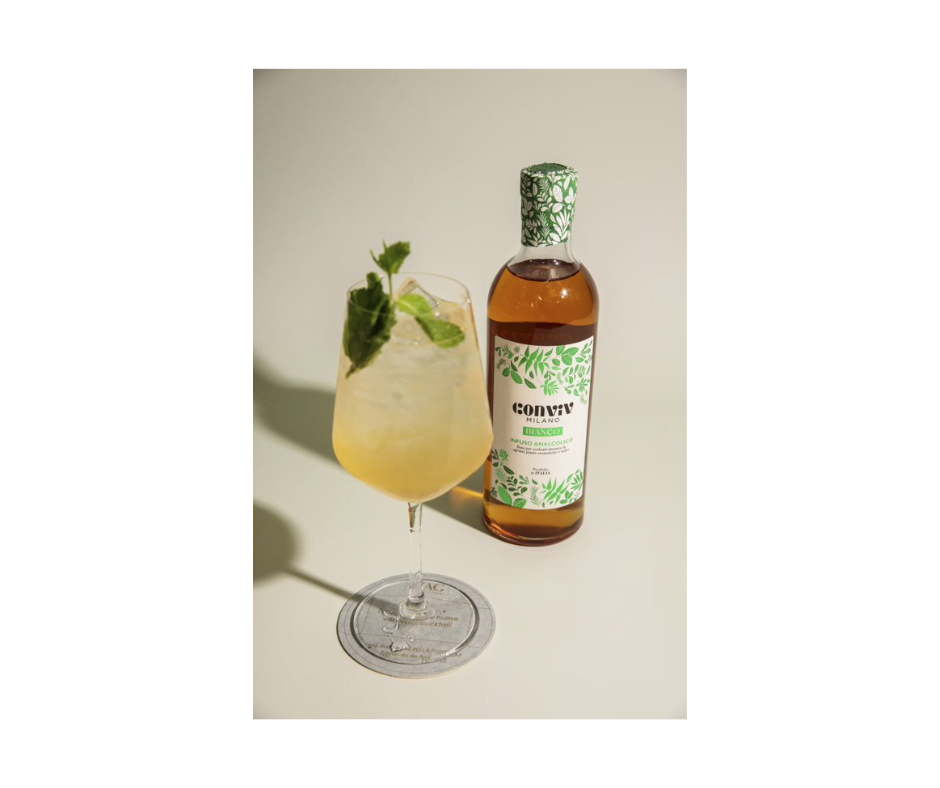 Conviv HG alcoholvrije cocktail. Een fles Conviv Tonic met de cocktail in een groot wijnglas met veel ijsblokjes en een takje munt. Cheers