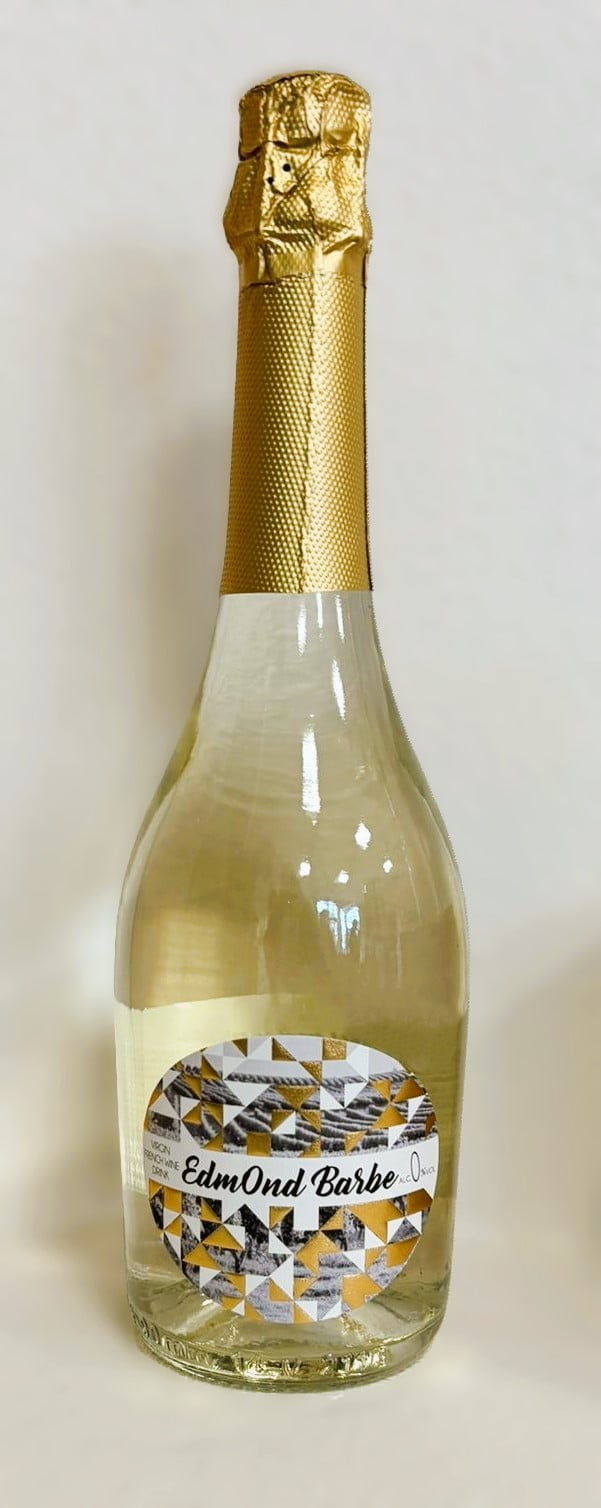 Een fles Edmond Barbe met zilver-gouden etiket en gouden capsule om de flessenhals